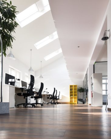 Desks with PCs in bright and modern open space office